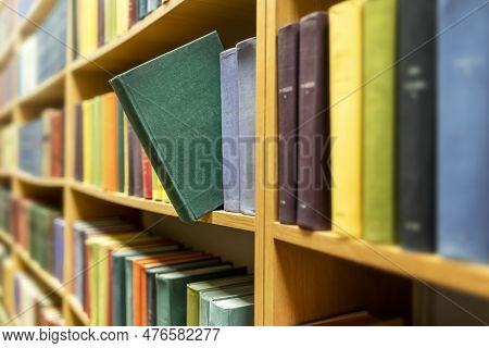 Green Book Extended From Colourful Books On Shelves In Public Library. Concept Of Education, Study, 