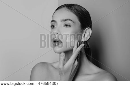 Attractive Girl Putting Anti-aging Cream On Her Face. Closeup Portrait Of Girl With Healthy Smooth S