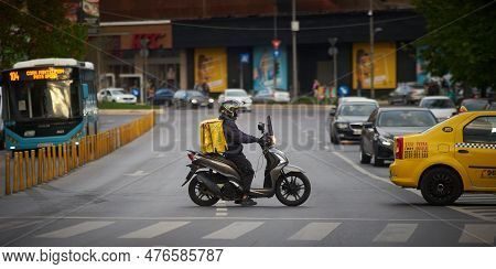 Bucharest, Romania - 3rd May, 2023: A Glovo Food Delivery Courier Delivers Food In Bucharest, Romani