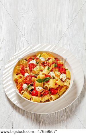 Roasted Pepper Tomato Mozzarella Pasta Salad In White Bowl On White Wood Table, Vertical View From A