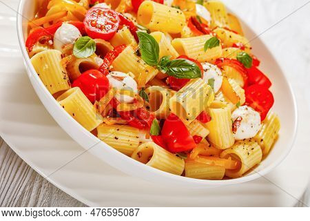 Close-up Of Roasted Pepper Tomato Mozzarella Pasta Salad In White Bowl On White Wood Table
