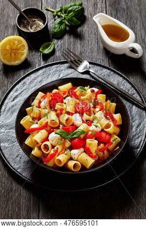 Roasted Pepper Tomato Mozzarella Pasta Salad In Black Bowl On Dark Oak Wood Table With Fork, Olive O
