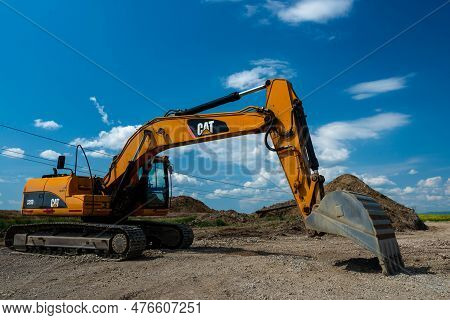 Sfantu Gheorghe, Romania- 21 May 2023: Caterpillar Excavator On Work Site , Blue Sky With White Clou