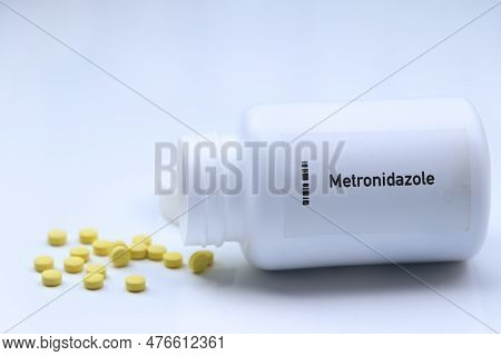 Metronidazole Pill In White Bottle, Pill Stock, Medical Or Pharmacy Concept