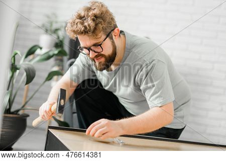 Young Attractive Man Assembles Furniture - Handwerker And Interior Objects Concept