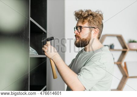 Young Attractive Man Assembles Furniture - Handwerker And Interior Objects Concept