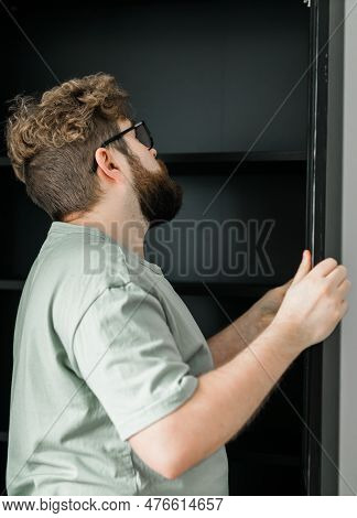 Young Attractive Man Assembles Furniture - Handwerker And Interior Objects Concept