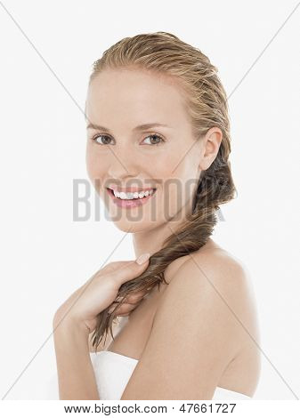 Portret młodej kobiety blond zawinięty w ręcznik na białym tle