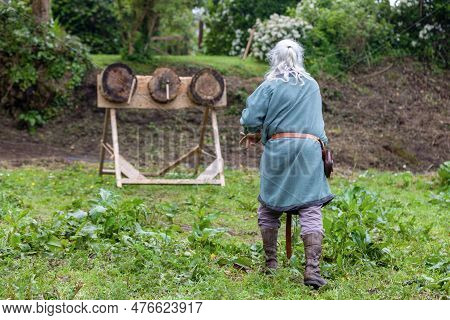 Medieval Era Man Practicing Axe Throwing On Three Targets.