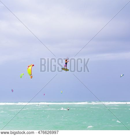 Kiteboarding. Fun In The Ocean. Extreme Sport Kitesurfing. Kitesurfer Jumping High In The Air Perfor