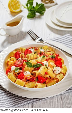 Roasted Pepper Tomato Mozzarella Pasta Salad In White Bowl On White Wood Table, Vertical View From A