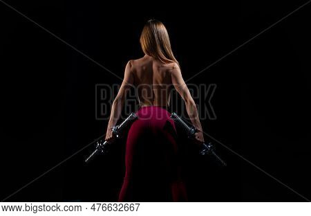 Sexy Fit Woman Works Out With Dumbbells On Black Dark Background. Athletic Young Woman Doing A Fitne