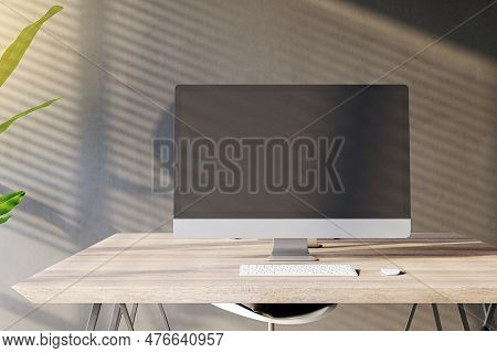 Front View Of A Home Workplace With Wooden Desk With Blank Screen Modern Computer On Dark Wall Backg