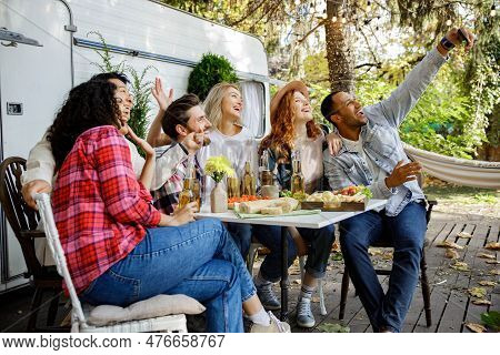 Friends Of Different Races Take A Selfie On A Mobile Phone In Nature. A Cheerful Company Of Women An