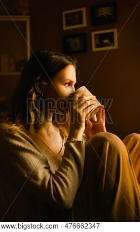 A Woman Wrapped In A Warm And Comforting Beige Loungewear, Enjoying A Moment Of Pure Bliss With Her 