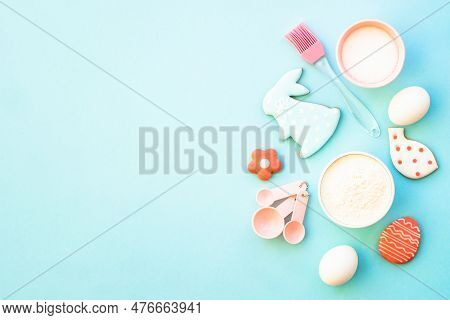 Easter Baking Background On Blue. Flour, Edds, Sugar And Gingerbread Cookies. Top View With Copy Spa