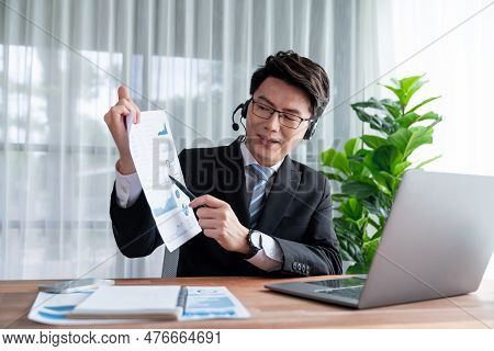 Confident Asian Telesales Businessman Work In Modern Office Wearing Headphone, Presenting Bi Dashboa