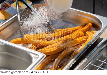 Chef Preparing Homemade Crunchy Churros With Powdered Sugar At Summer Outdoor Food Market - Close Up