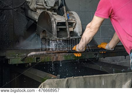 A Worker Cuts Granite. The Cutter Cuts Granite. Stone Processing Machine. Stone Cutting At The Facto