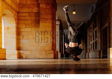 White Teenage Boy With Head On The Ground, Doing Head Spin, Breakdancing On Old City Street. Street 