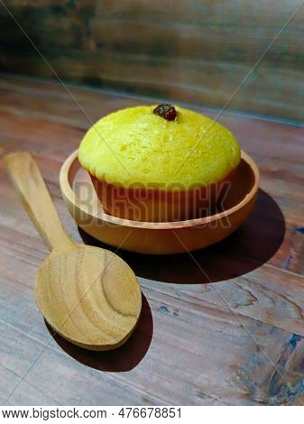 A Mud Cake With Raisin Topping Against A Background Of Wood Texture