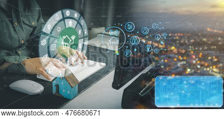 Man Holding Small Home Model, Mobile Phone With Virtual Display As Assistant House Remote Control. S