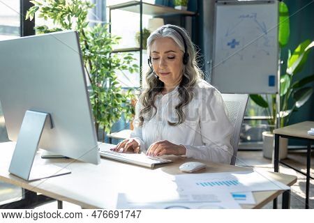 Good-looking Mature Business Woman At The Computrer Looking Busy