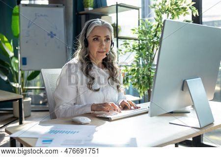 Good-looking Mature Business Woman At The Computrer Looking Busy