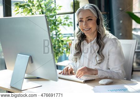 Good-looking Mature Business Woman At The Computrer Looking Busy