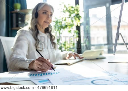 Good-looking Mature Business Woman At The Computrer Looking Busy