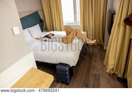 Young Woman Lying On Bed In The Hotel Rooma And Feeling Relaxed