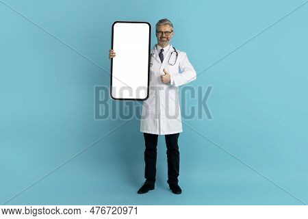 Friendly Middle Aged Doctor Showing Nice Telemedicine App On Smartphone
