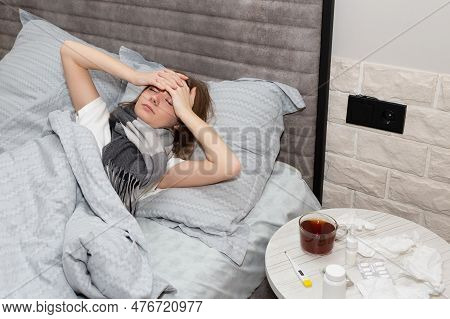 A Sick Beautiful Young Girl, Holding Her Forehead With Both Hands Because Of A Severe Headache In Th