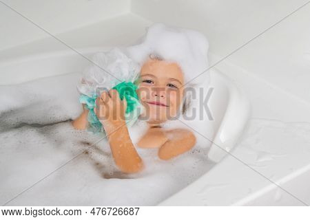 Kids Face In Foam. Child In The Bath With Bubbles. Happy Child Enjoying Bath Time. Little Boy Smilin