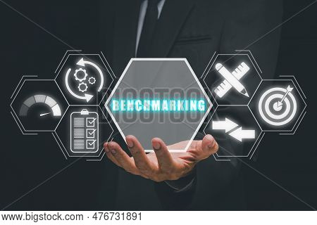 Benchmarking Concept, Businessman Hand Holding Benchmarking Icon On Virtual Screen.