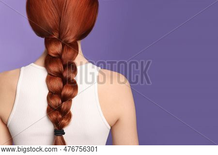 Woman With Red Dyed Braided Hair On Purple Background, Back View. Space For Text