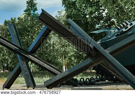 Anti-tank Hedgehogs And Tank Closeup And Peaceful Background. Monument To Old Weapons Close-up. Symb
