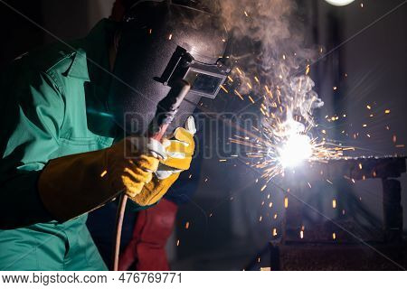 Metal Welding Steel Works Using Electric Arc Welding Machine To Weld Steel At Factory. Metalwork Man