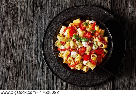 Roasted Pepper Tomato Mozzarella Pasta Salad In Black Bowl On Dark Oak Wood Table, Horizontal View F