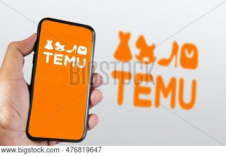 Boston, Us, March 2023: Hand Holding A Phone With Temu Logo Displayed On The Screen. Blurred Logo On