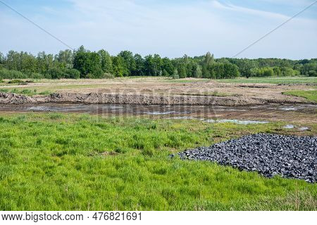 Scenic View Over Grass, Natural Flood Are And Rocks Near The River Scheldt, Tielrode, Flanders, Belg