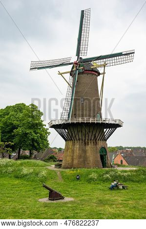 Hulst, Zeeland, The Netherlands - May 21, 2023 - Green Lawn With An Old Windmill