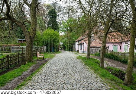 Uccle, Brussels Capital Region, Belgium - May 10, 2023 - Cobblestone Road And Farmhouse In The Fond'