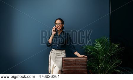 Young Female Entrepreneur In Thought Sitting On The Floor In The Kitchen With A Laptop On Her Legs