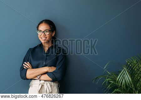 Young Female Entrepreneur In Thought Sitting On The Floor In The Kitchen With A Laptop On Her Legs
