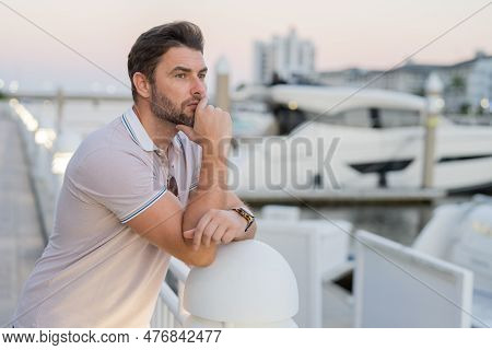 Rich Business Man Dreaming And Thinking Near The Yacht. Sexy Man In Casual Clothes Posing On The Str