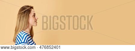 Profile View Portrait Of Young Girl In Striped Shirt Posing, Looking Straigh Against Yellow Studio B