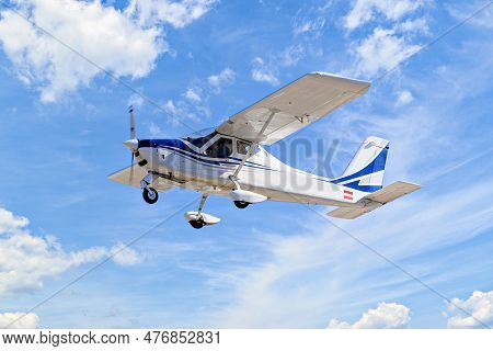 Single Engine Ultralight Plane Flying In The Blue Sky With White Clouds