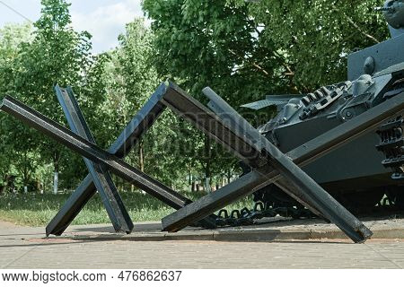 Mogilev, Belarus May 21 2023 Anti-tank Hedgehogs And Tank Closeup And Peaceful Background. Monument 