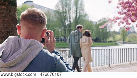Man Paparazzi Photographer Capturing A Photo Suspiciously Of Couple Walking Together